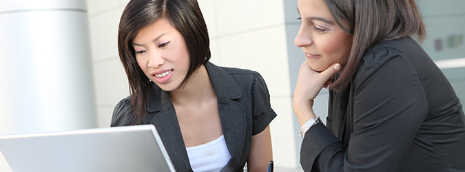 Two women follow a QIP tutorial on a laptop 
